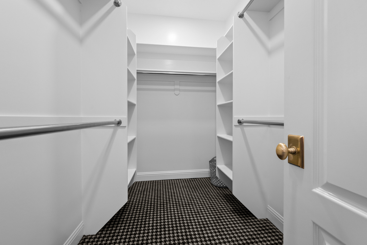 A spacious walk-in closet with built-in shelving and abundant hanging space provides convenient storage for longer stays and effortless organization.