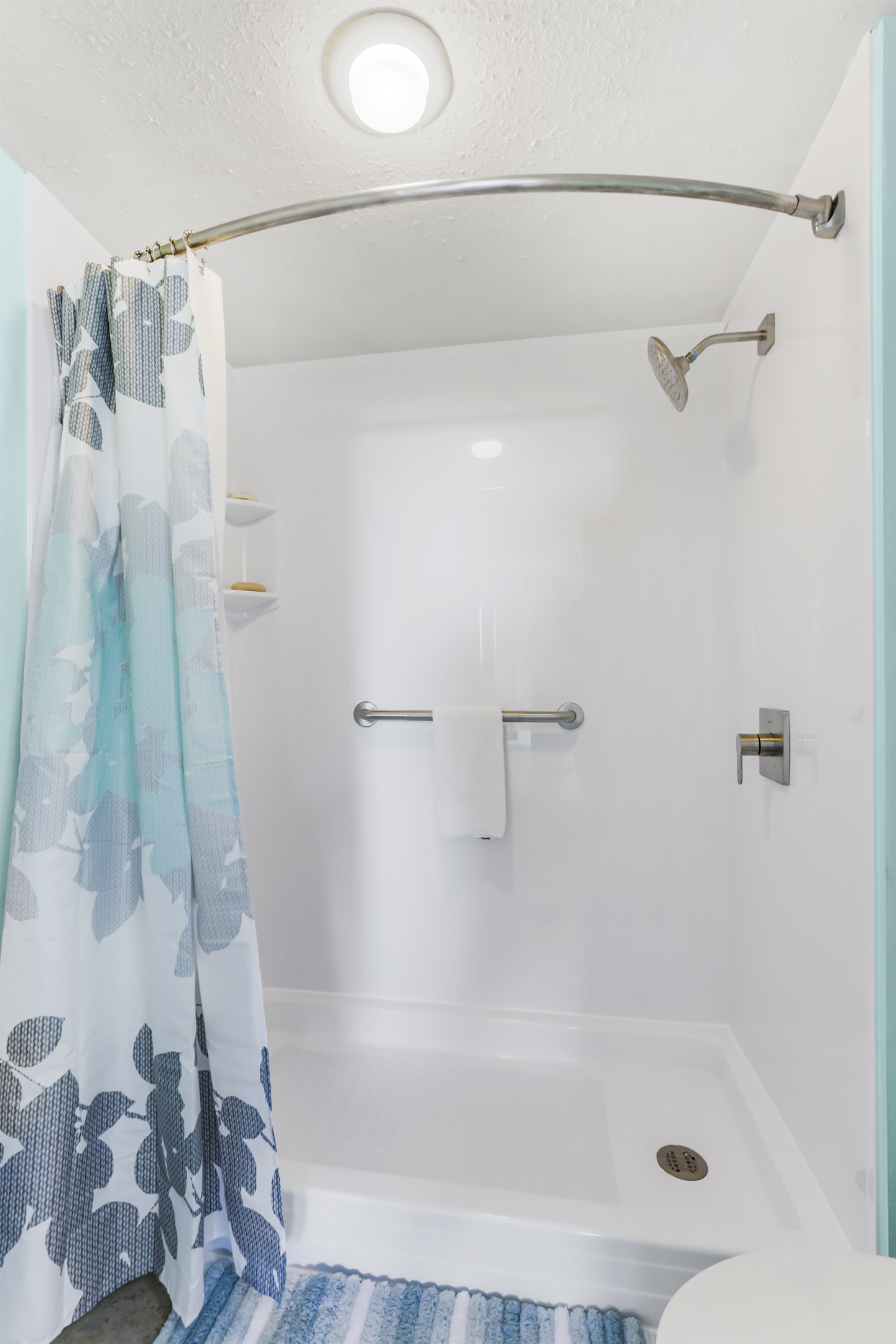 Step-in shower with grab bars and non slip mat. Grab bar next to toilet. Hooks for your towels. 