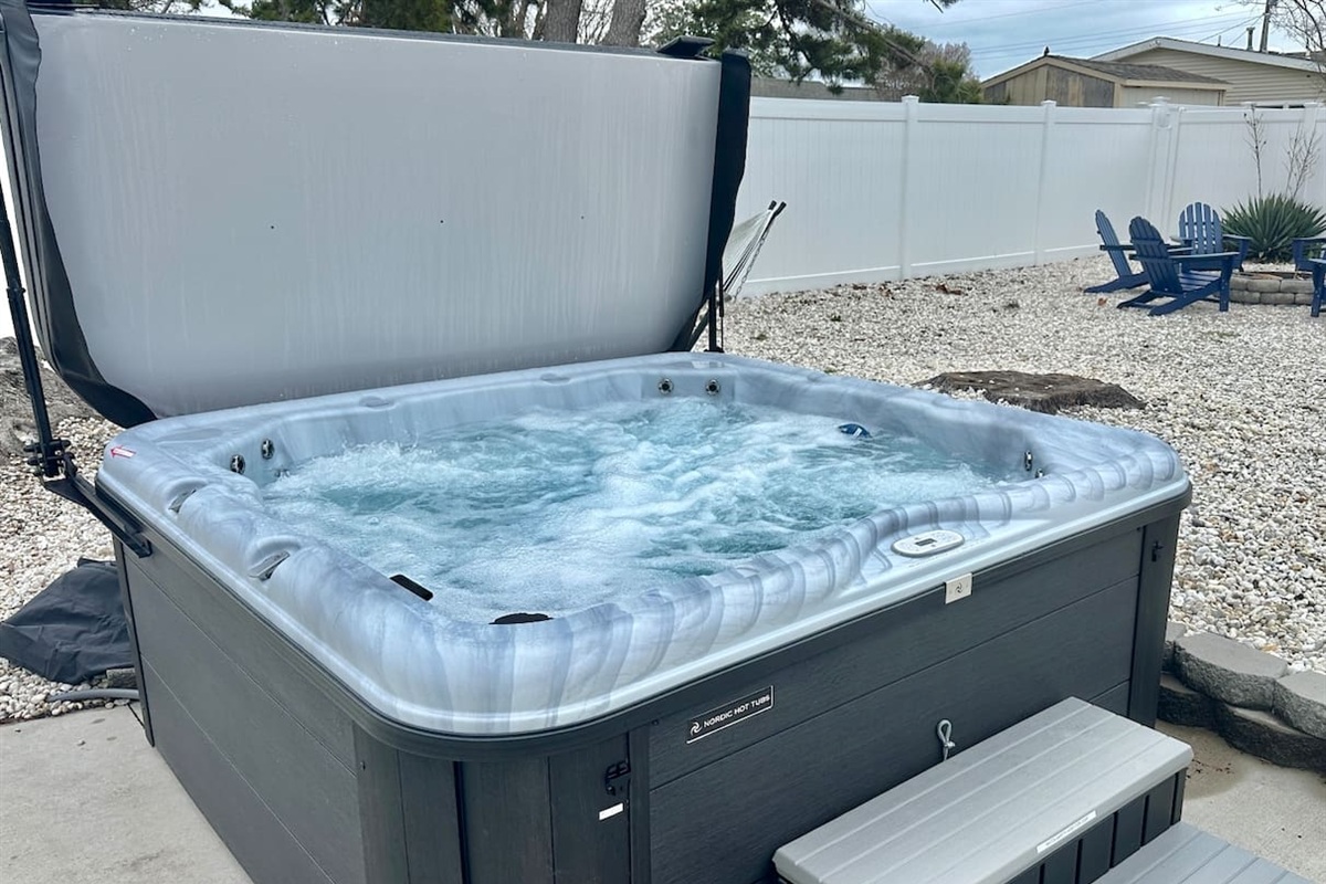 Unwind in our private hot tub, perfectly situated for stargazing. The fenced backyard also features a gravel lounge area with Adirondack chairs—the ultimate spot for evening relaxation and fresh air.