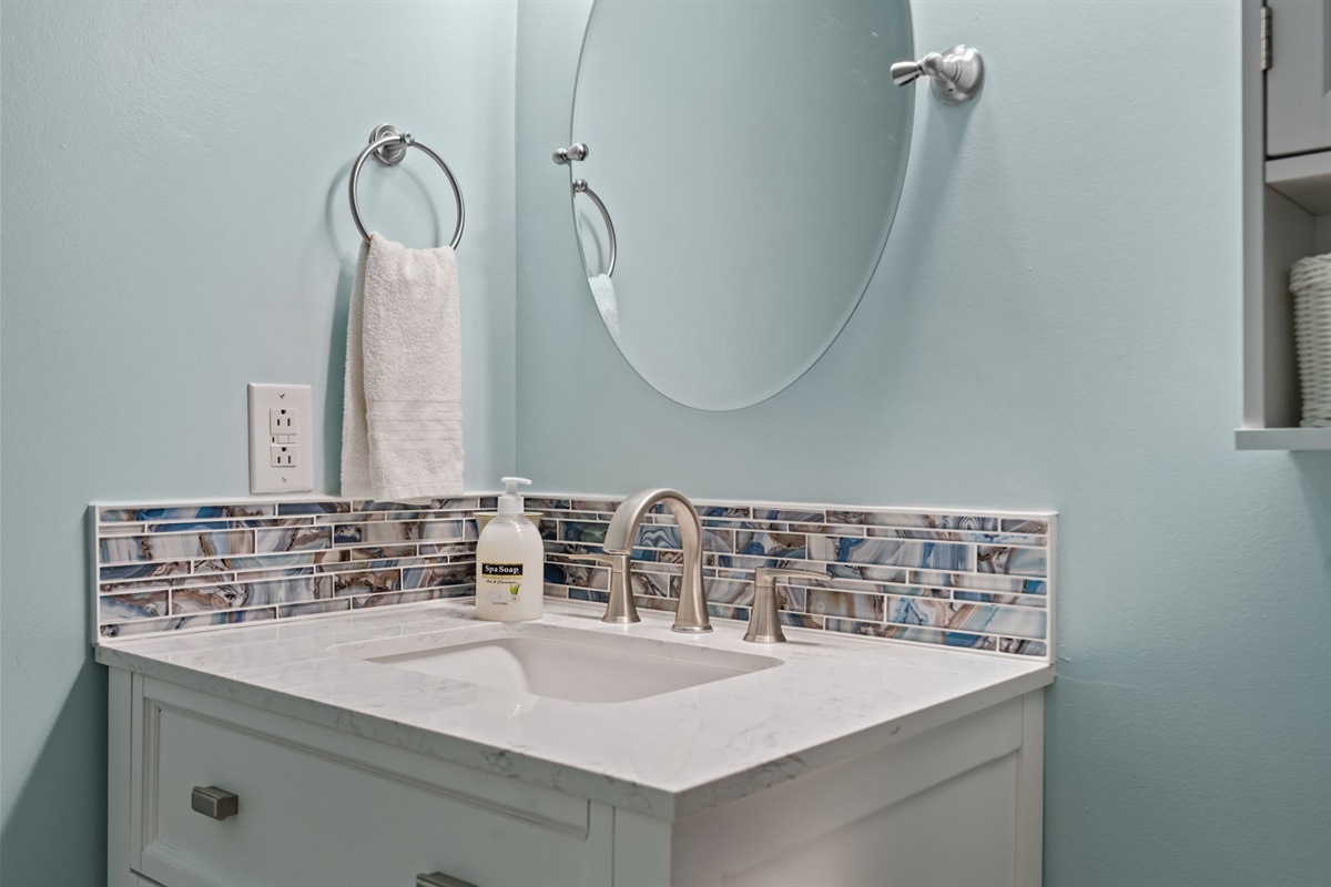 Updated Master bathroom vanity with modern sink, stylish tile backsplash, and ample counter space