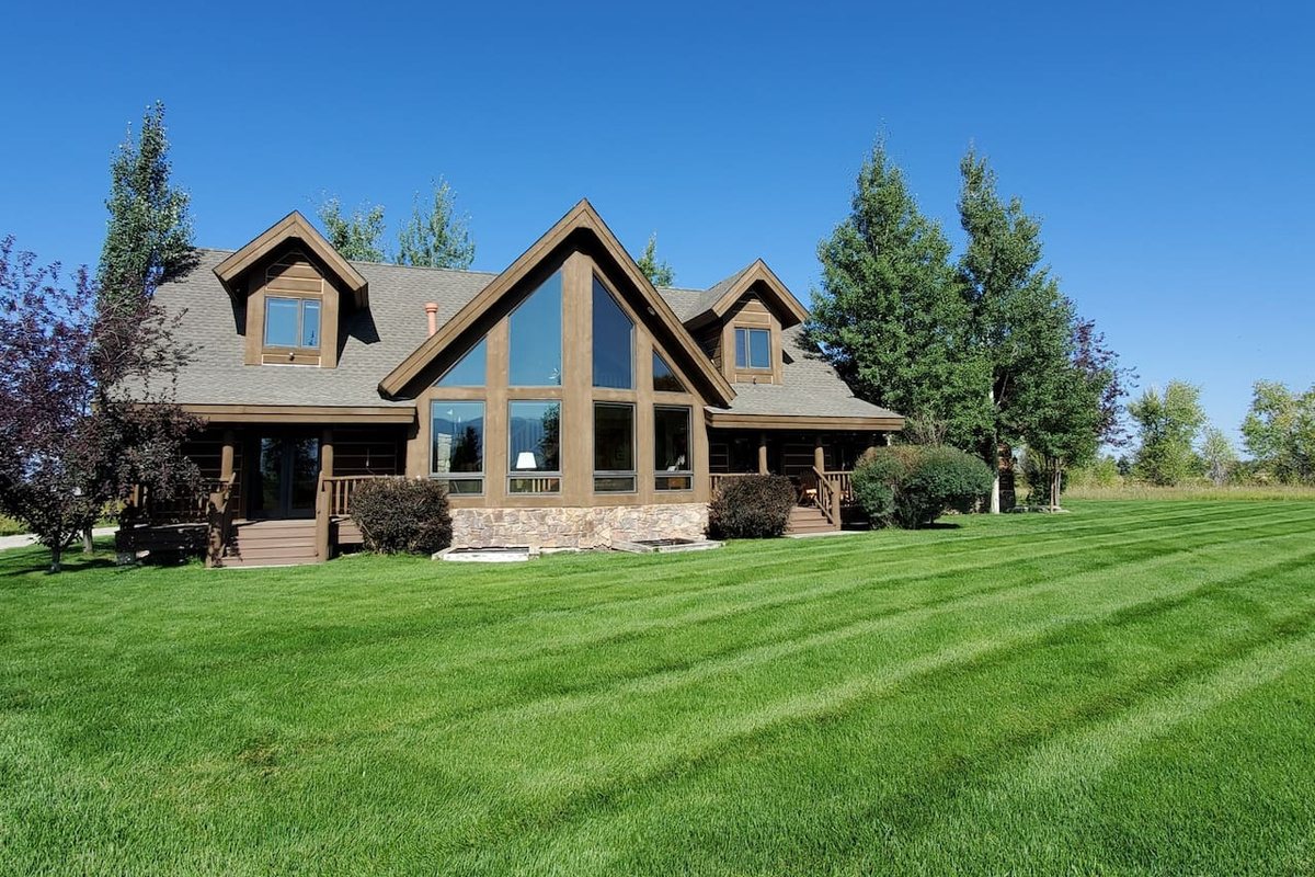 Soak in the beauty of this stunning A‑frame retreat, set on expansive, manicured grounds and surrounded by open space. The home’s striking architecture and dramatic windows create a warm, inviting space to relax and enjoy the peaceful setting.