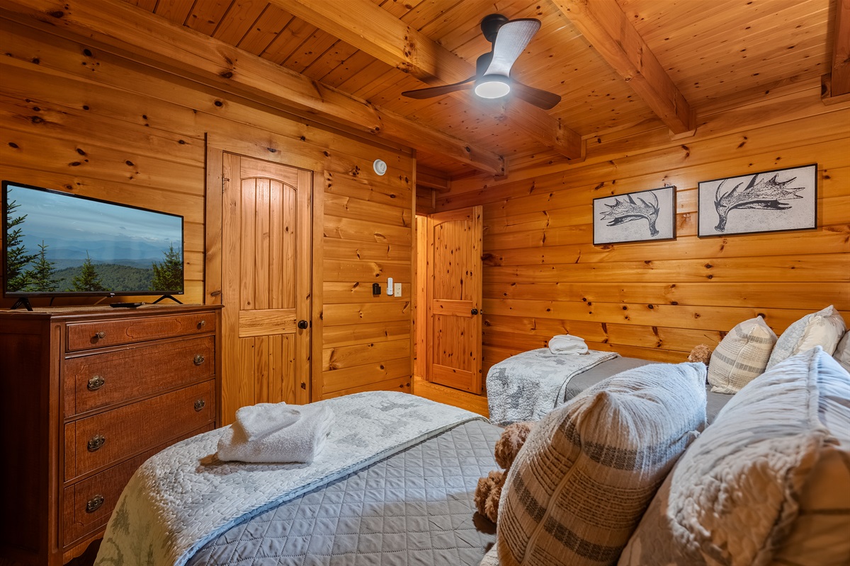 The cozy twin bedroom is perfect for kids or additional guests, featuring two comfortable twin beds, and a TV for relaxing with a movie or favorite show after a day of Smoky Mountain fun.