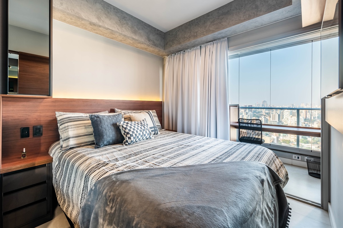 Conforto e vista panorâmica ✨ Cama confortável com enxoval premium, cortinas blackout e janela integrada à varanda com vista panorâmica da cidade.