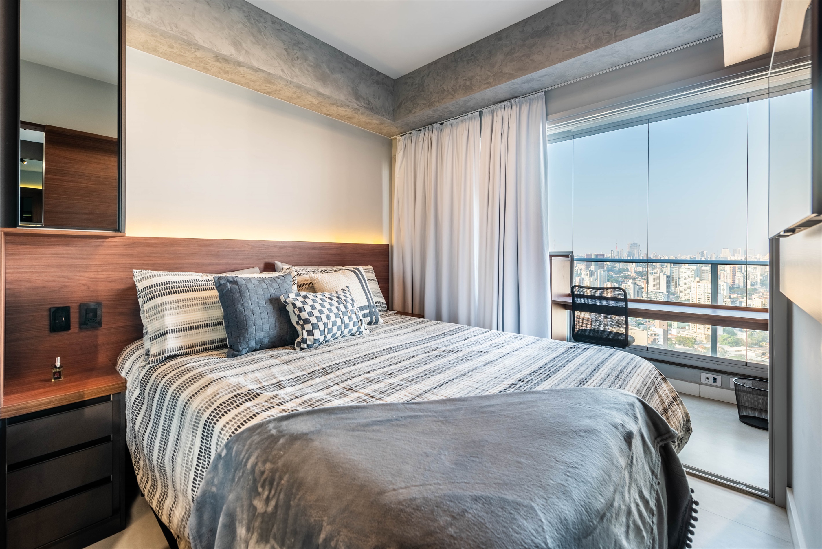 Conforto e vista panorâmica ✨ Cama confortável com enxoval premium, cortinas blackout e janela integrada à varanda com vista panorâmica da cidade.