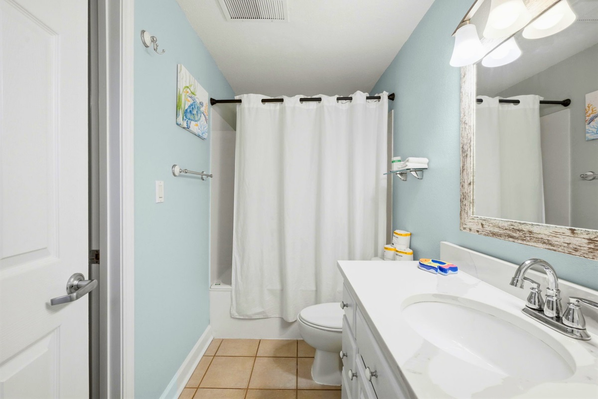 Fresh, clean, and bright, this bathroom offers a convenient shower and tub combination.