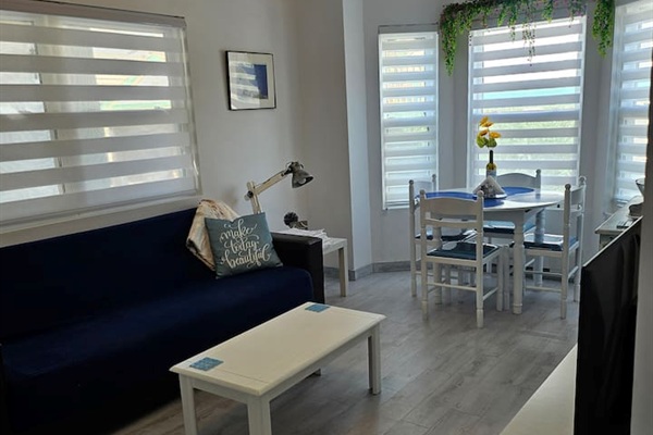 Living area with dining table for 4 guests, futon that folds in a single bed for 1 adult or 2 small children, and app TV.