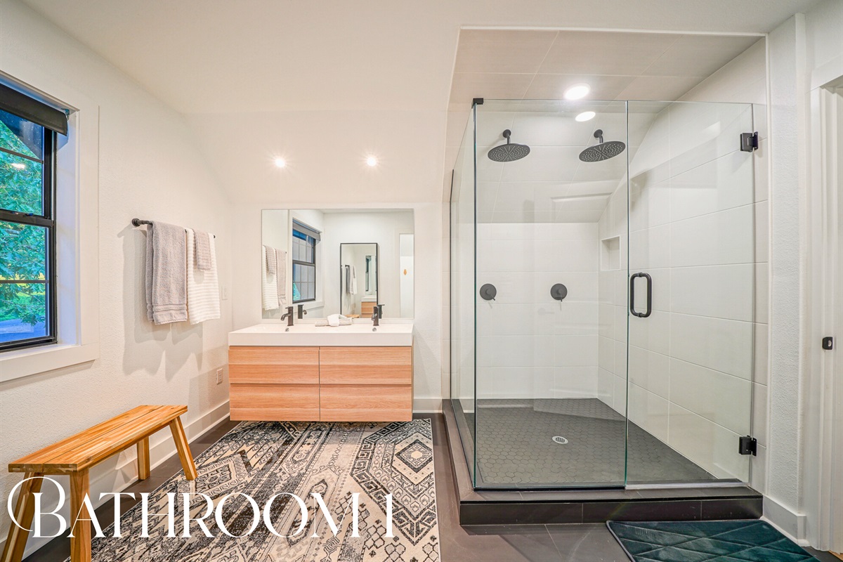 Get spa-level luxury with dual rainfall showerheads, a floating vanity, and sleek tile — refreshing has never felt so indulgent.