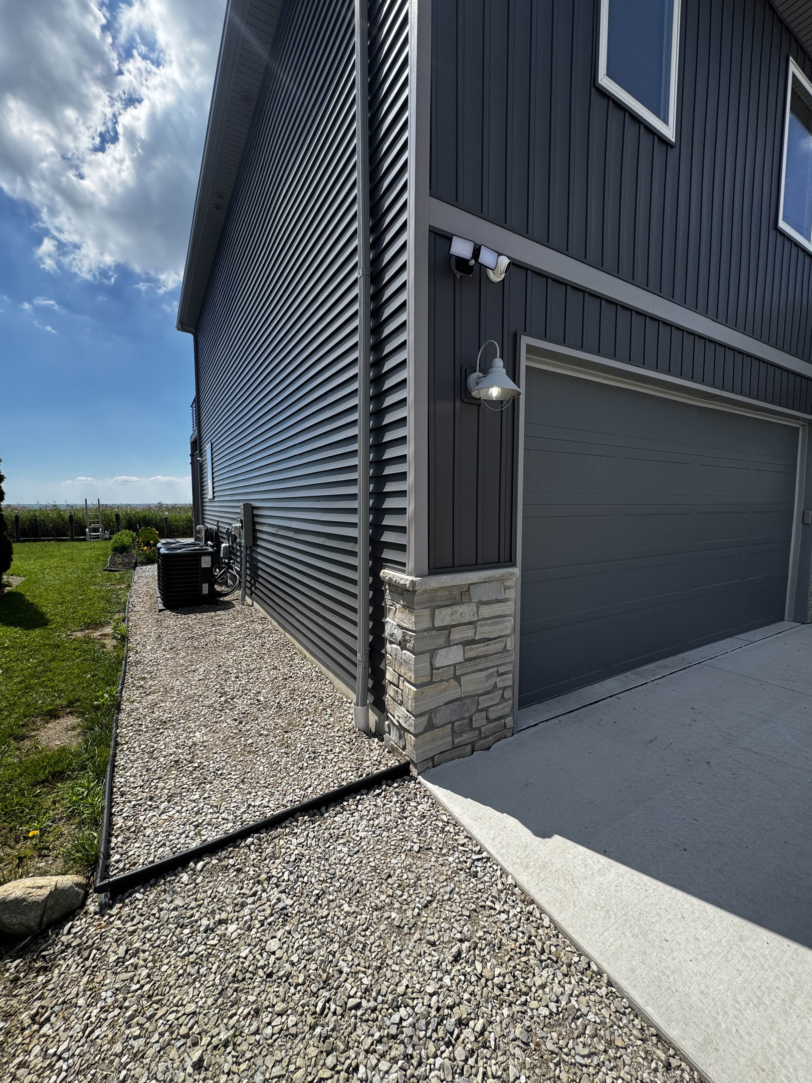 Clean side walkway with gravel and stepping edge along the exterior of the home, connecting the driveway and backyard spaces.