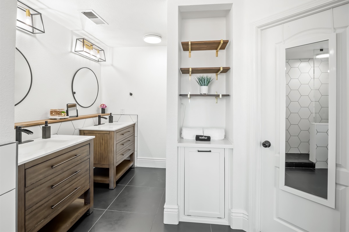 Large mirrors and modern lighting keep the space bright and practical, while plenty of drawers provide storage for everyone’s essentials.