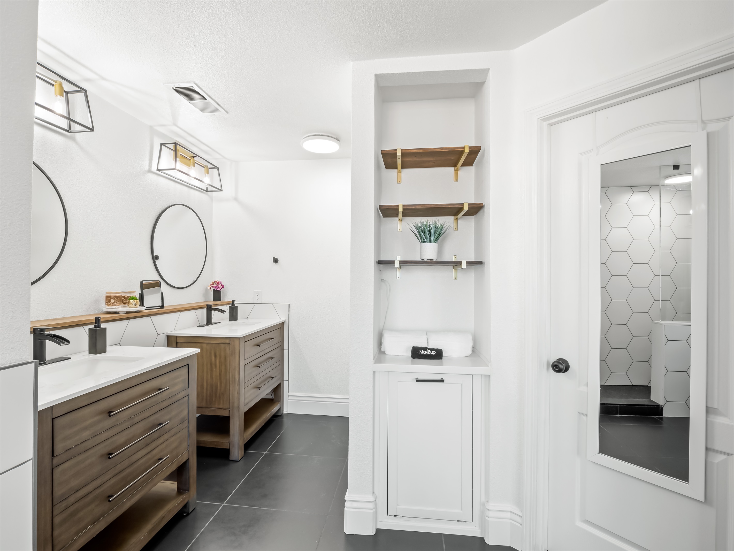 Large mirrors and modern lighting keep the space bright and practical, while plenty of drawers provide storage for everyone’s essentials.