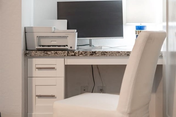 Efficient dedicated workspace with a monitor and printer, designed for productivity and organization.