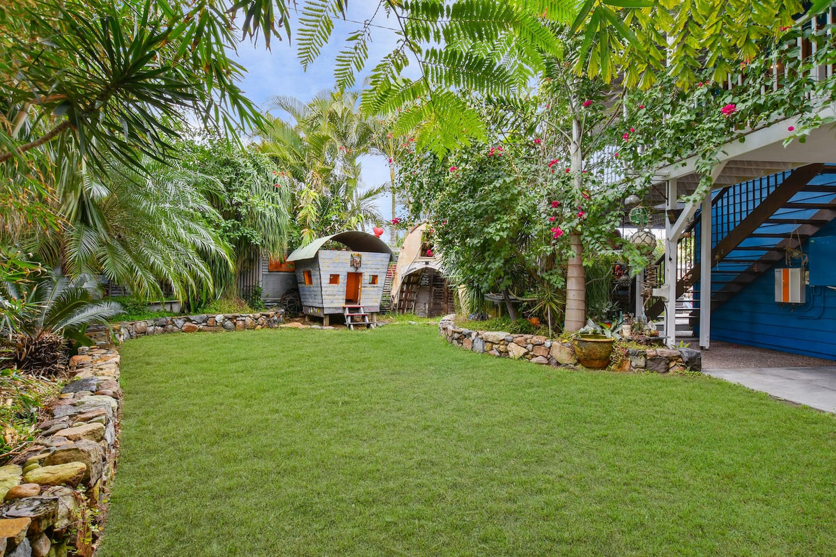 Dense tropical planting, flowering greenery and the character-filled garden setting give the backyard at Aaron's Beachside Boat House a private, distinctive feel.