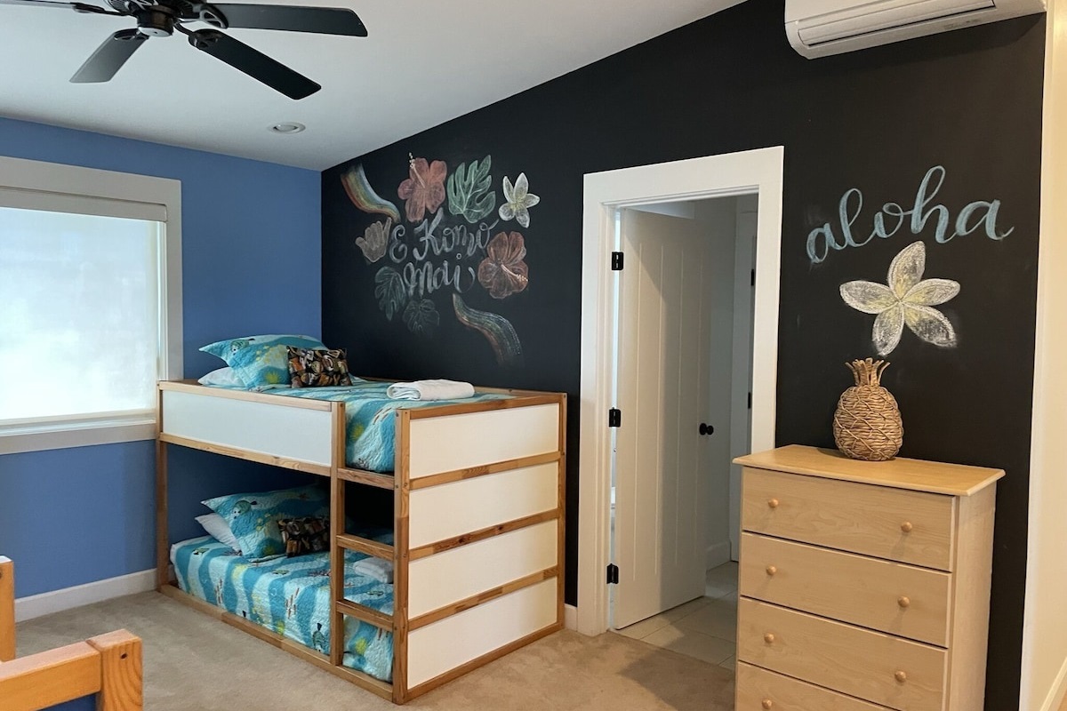 Open style Keiki room with 2 bunk beds and chalkboard wall.
