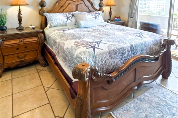 King bedroom with Smart TV, ceiling fan, and ocean-view patio access.