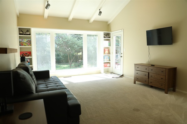 Den showing queen size sleeper sofa, dresser, Roku TV, nightstands, and games