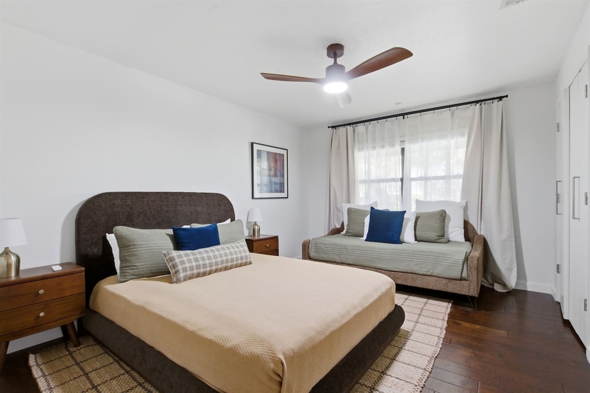 Bedroom featuring both a twin and a queen bed, equipped with room-darkening shades and comfortable mattresses to ensure a restful and flexible sleeping setup for families or groups.
