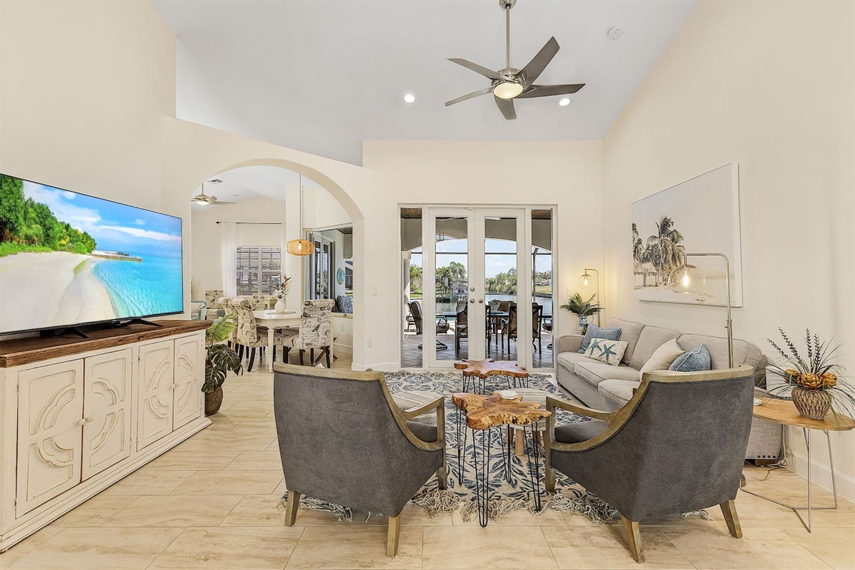 Spacious living room with captivating views of the pool and water!