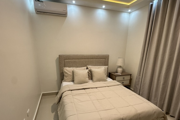 Cozy second bedroom with a queen bed, A/C, warm ambient lighting, and a closet with built-in drawers for storage. 🛏️✨