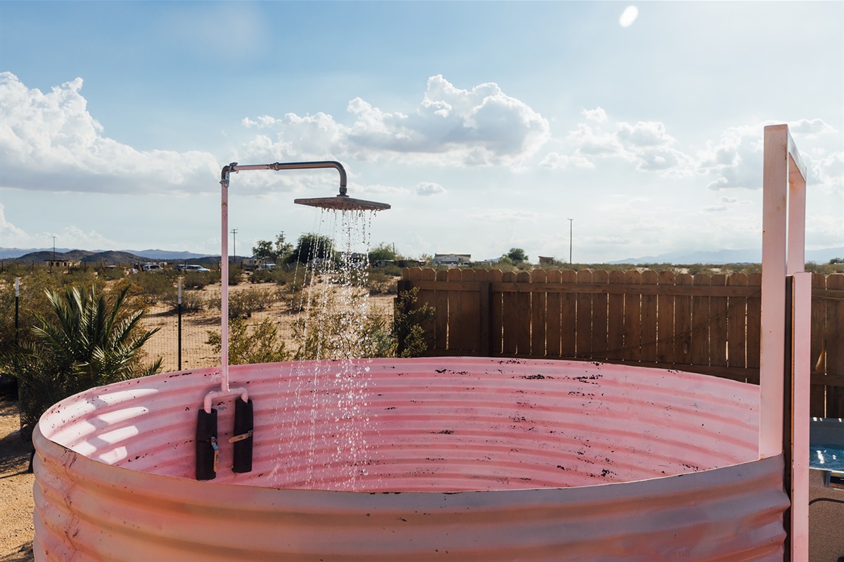 Close-up of the unique outdoor pink shower, blending playful design with desert adventure.