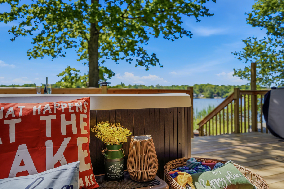 Hot tub with open lake views and tree canopy overhead — day or night, it delivers