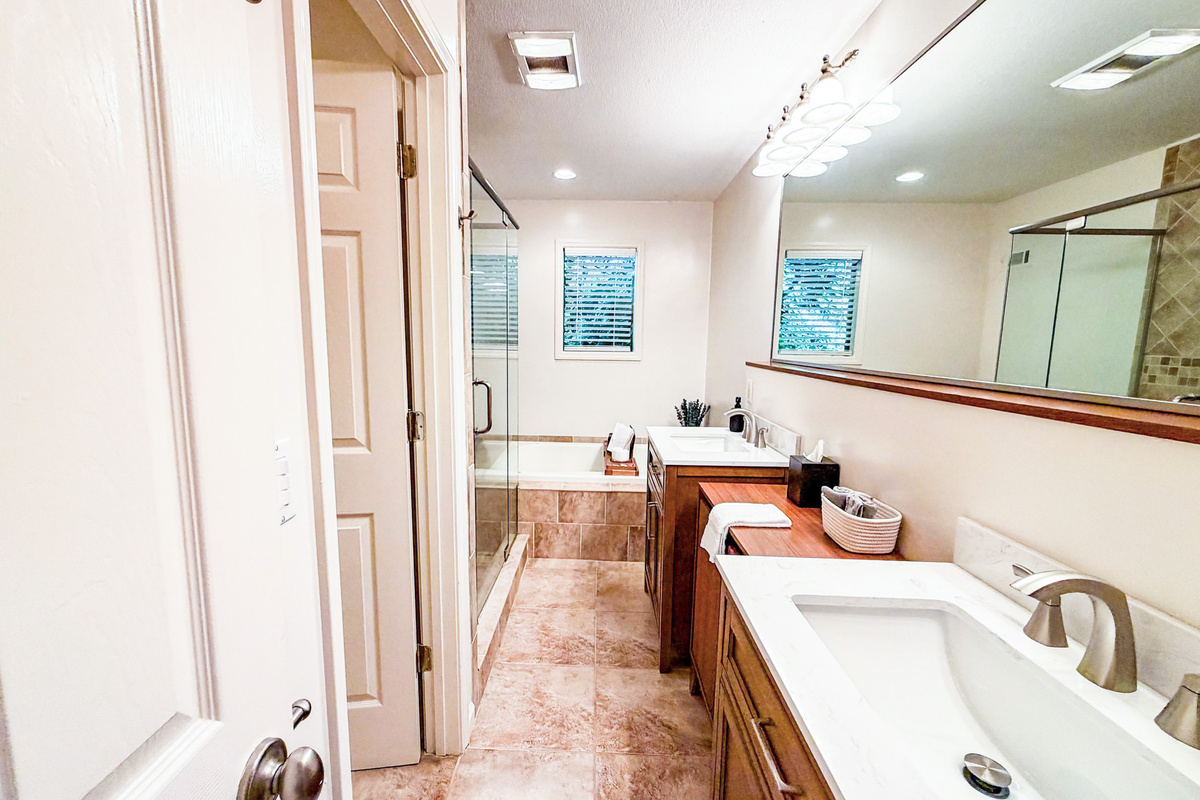 The master en-suite bathroom features dual vanities, a private water closet, a beautifully tiled shower, and a whirlpool tub.