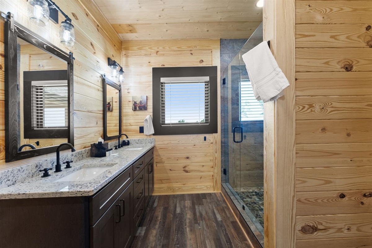 Bright and modern full bathroom with large window views and a glass walk-in shower—comfort meets cabin charm.