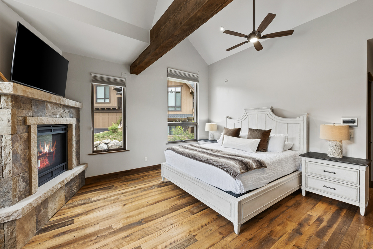 Spacious primary bedroom with King bed, large windows, large walk-in closet, tv and vaulted ceiling.