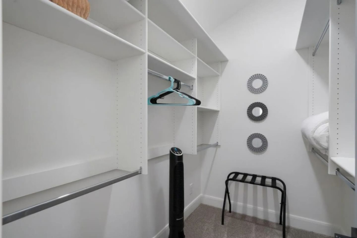 Spacious walk-in closet with custom shelving, hanging space, and organizational storage.