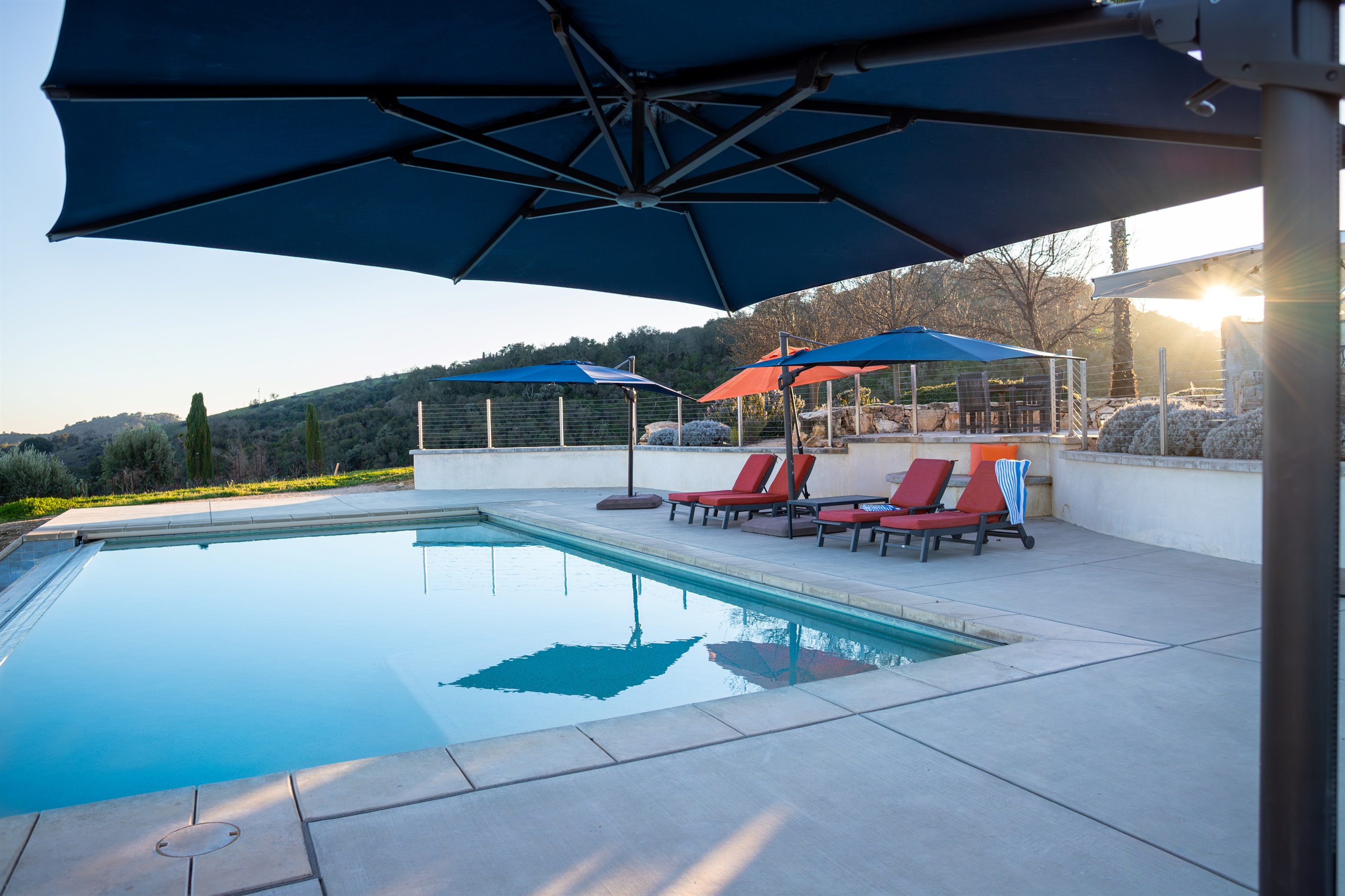 The golden hour hits different at 1,700 feet. The hilltop pool deck glows at sunset, with vineyard hills rolling out in every direction.