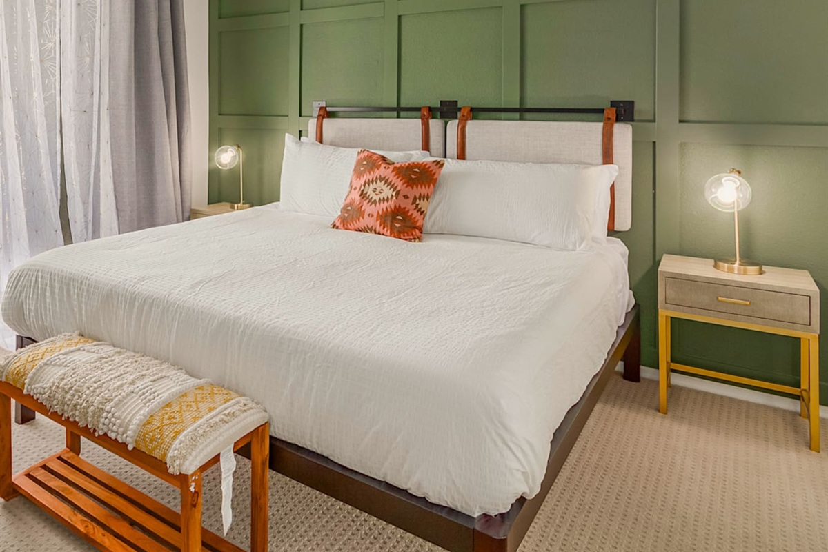 Spacious bedroom with king bed, workspace, and simple storage for short or extended stays.