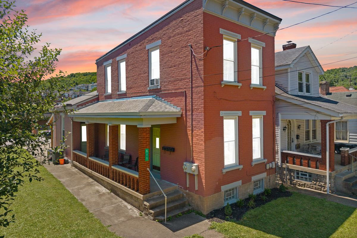 Classic red brick exterior with green lawn and timeless curb appeal