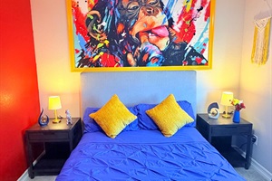 Queen bedroom featuring a comfy bed with plush pillows and a padded headboard.
