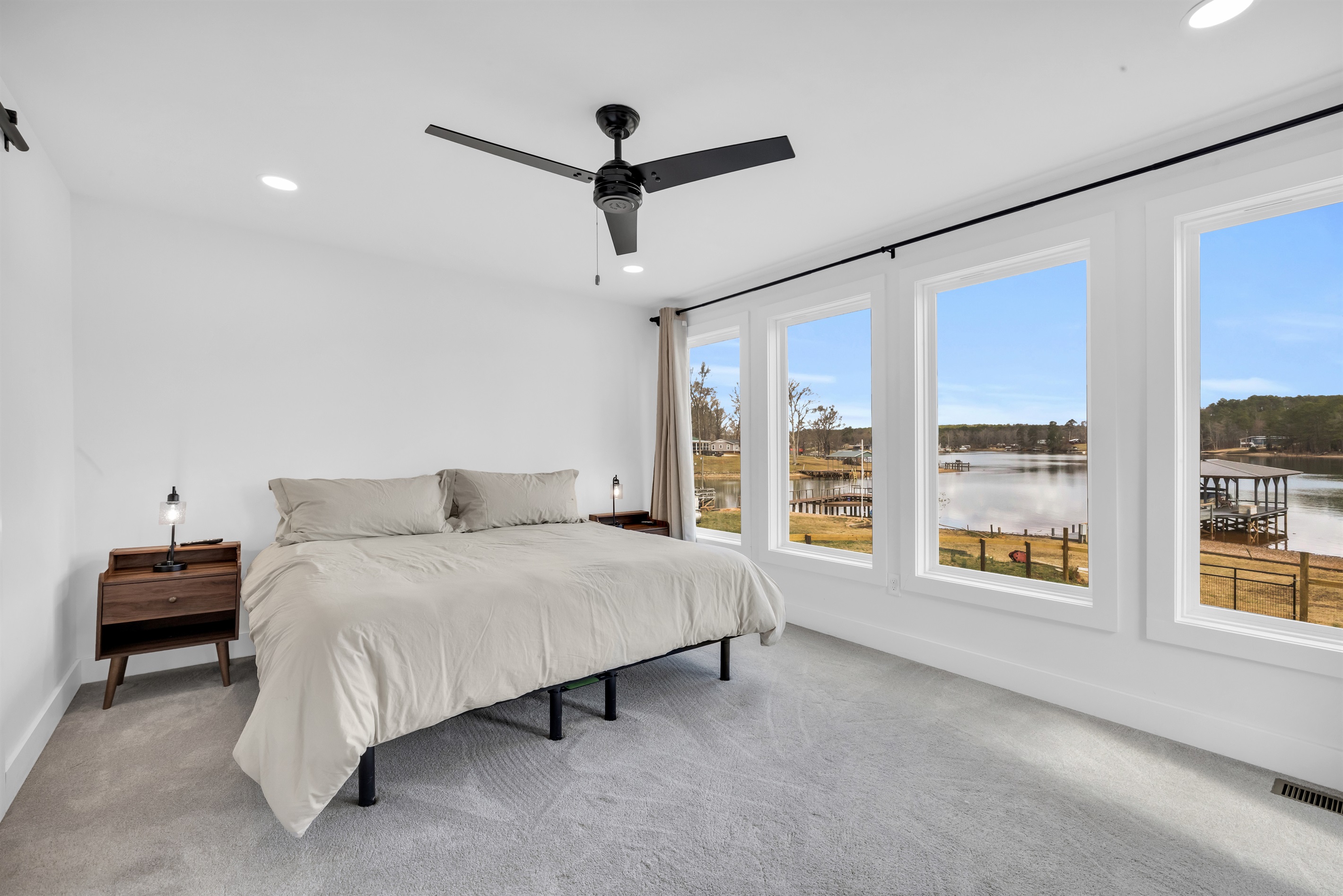Master bedroom with king bed and a view of the lake 