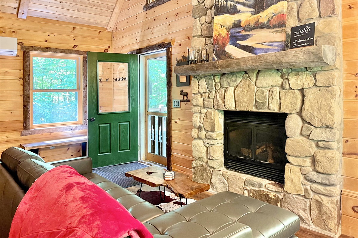 Gather around the floor-to-ceiling stone gas fireplace with split log mantlepiece. 