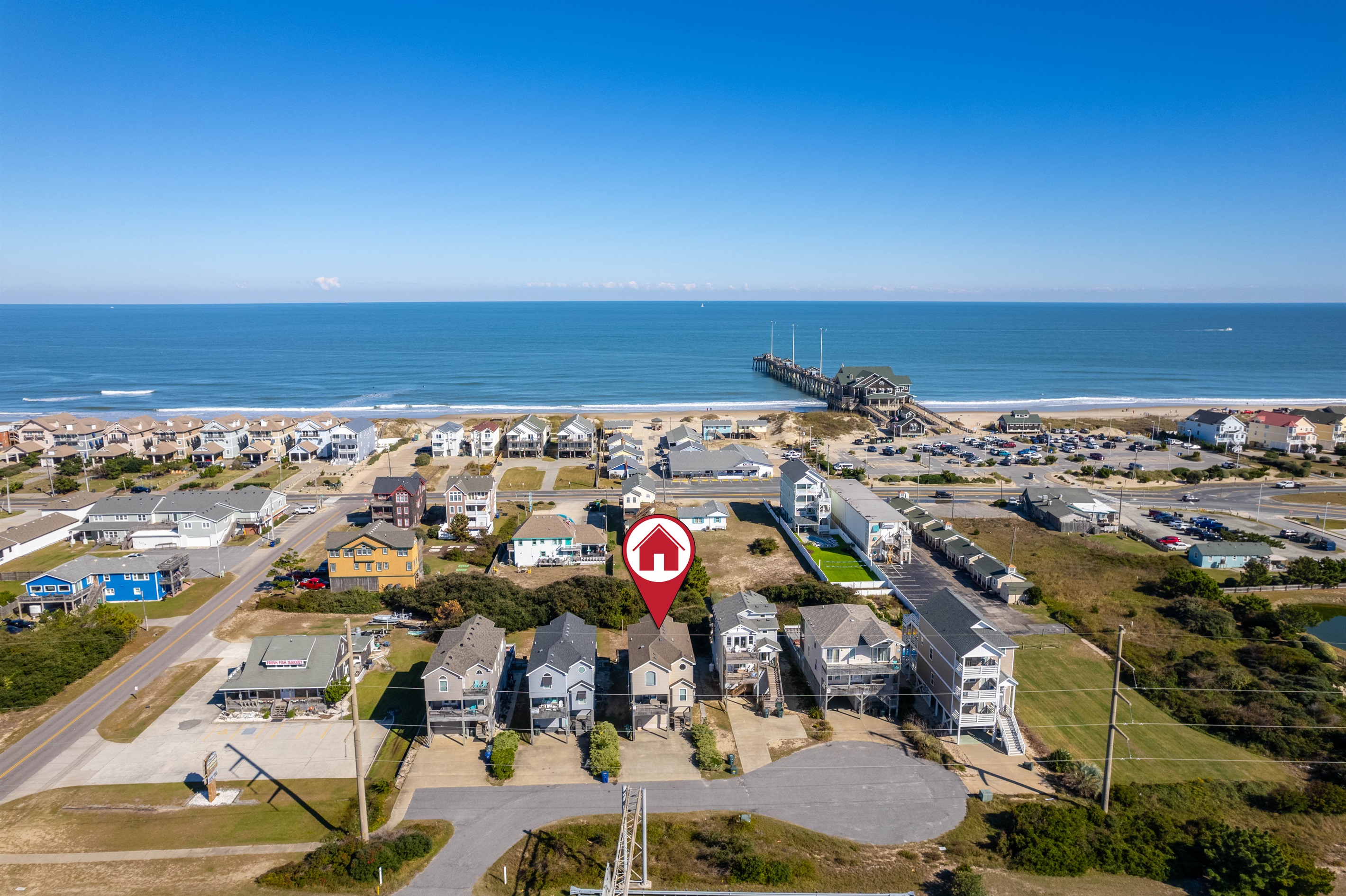 Bird’s-eye view of the property in relation to the coastline, with the pier and beach access visible just steps away.