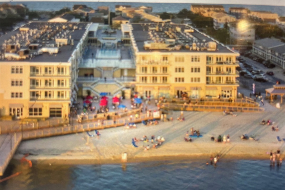 Aerial view of back of building with bay beach and boardwalk areas