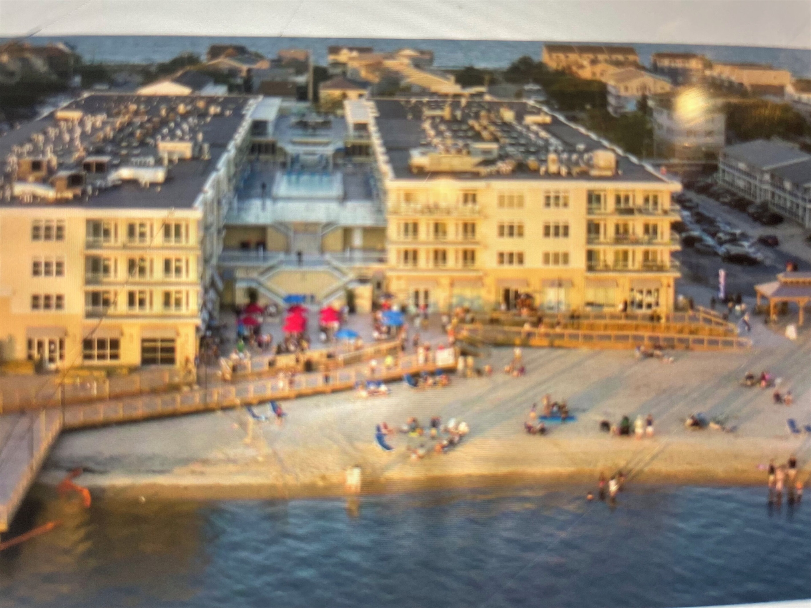Aerial view of back of building with bay beach and boardwalk areas