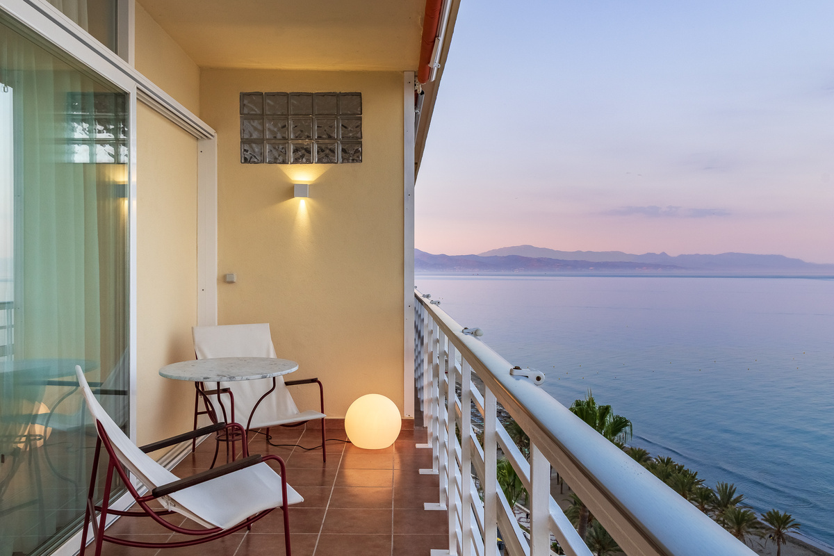 Sunset balcony view across the sea towards the mountains.