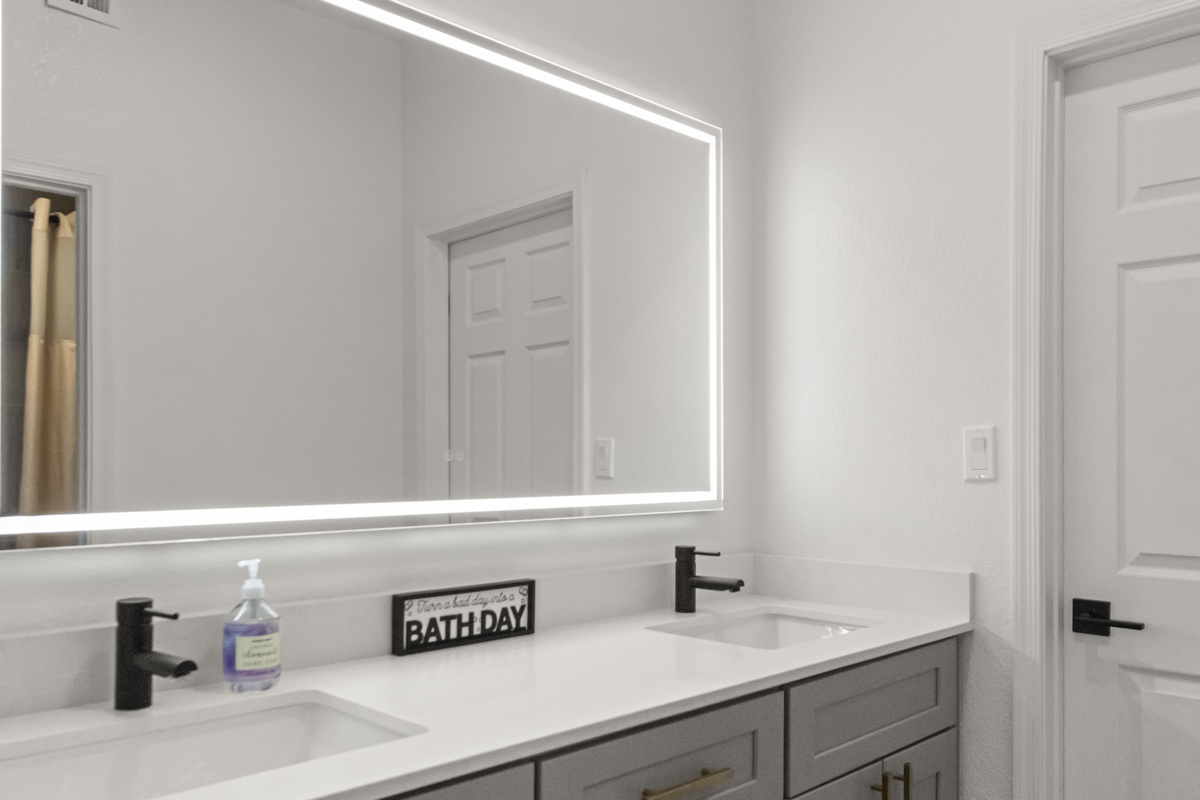 Bright, modern bathroom with a spacious double vanity, large mirror, and convenient walk-in shower.