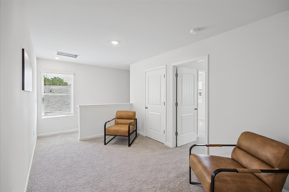 Upstairs sitting area with two comfy chairs, a quiet spot to read or unwind
