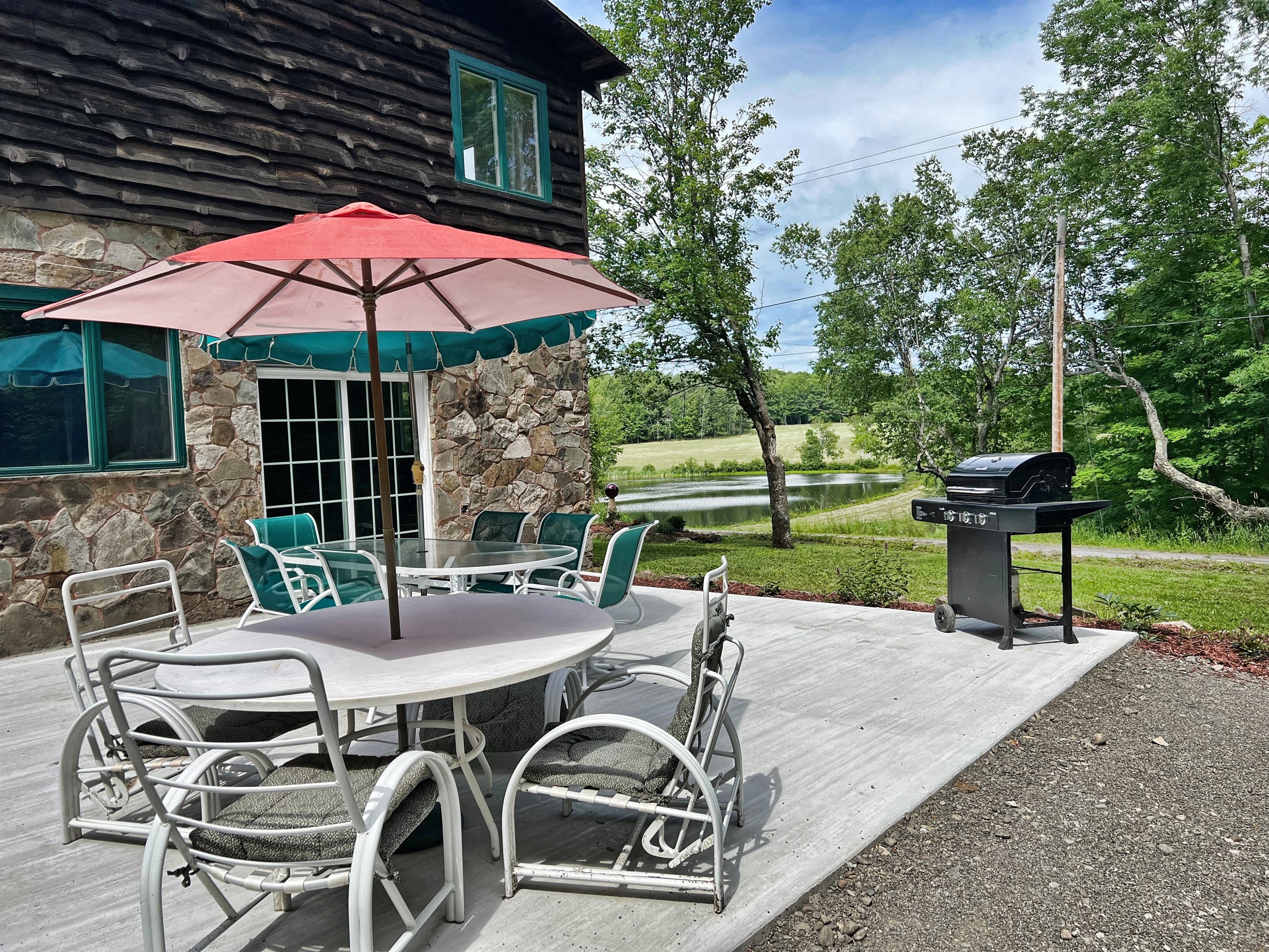 Stolk's Lodge patio located off the great room, with gas grill and seating. All overlooking to beautiful private pond.