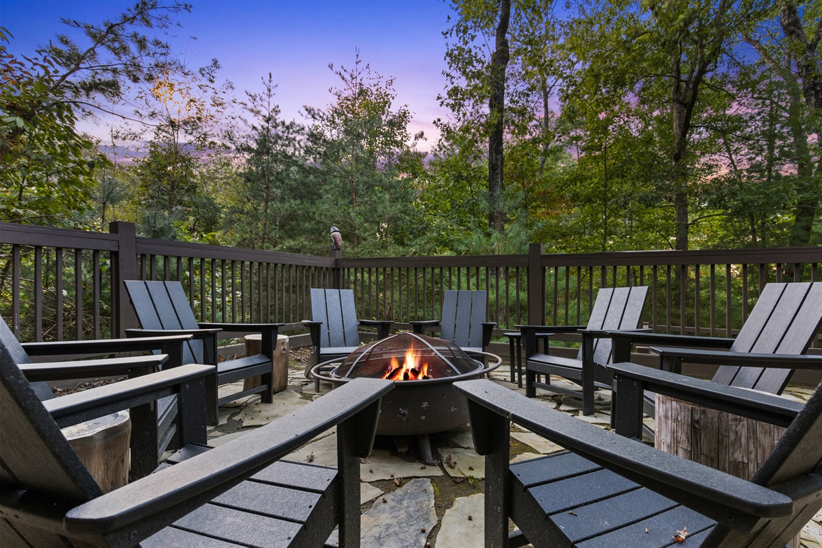 Gather by the fire pit, where tall trees frame every story told under the stars.