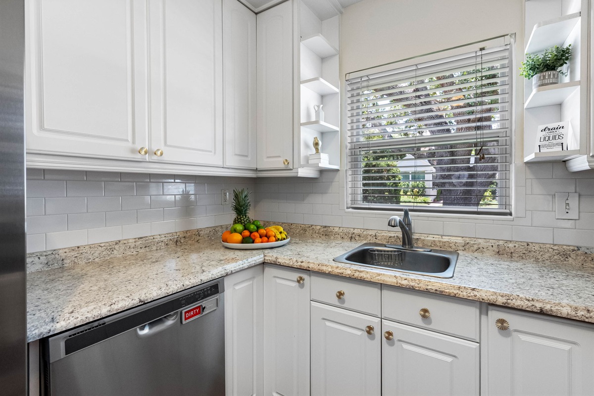 A harmonious blend of white cabinetry, sleek granite, and soft natural light—perfectly designed for everyday meals or vacation indulgence.