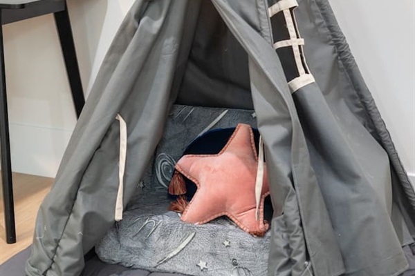 Play tent corner adds a fun, kid-friendly touch to the room.