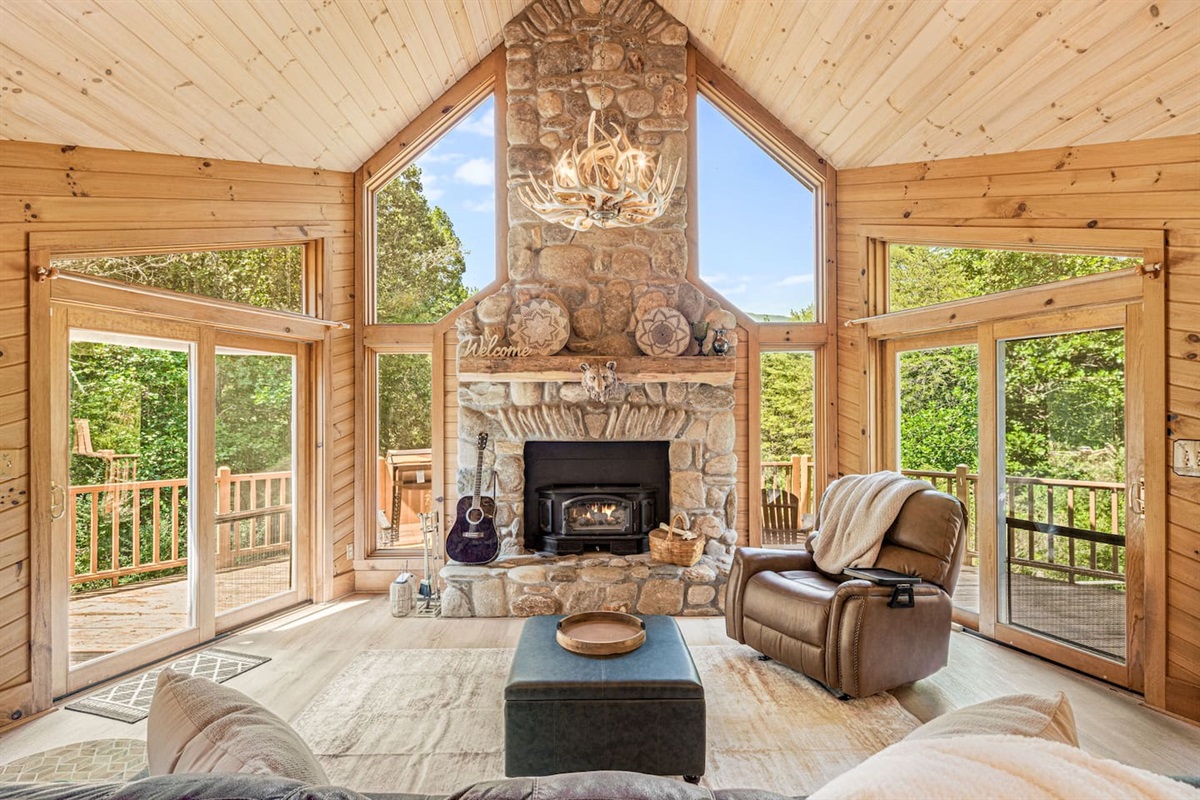 Relax in this cozy living room, where floor-to-ceiling windows showcase stunning mountain views. Curl up by the stone fireplace with a good book and soak in the warm, rustic charm. This is the perfect place to reconnect with nature and loved ones.