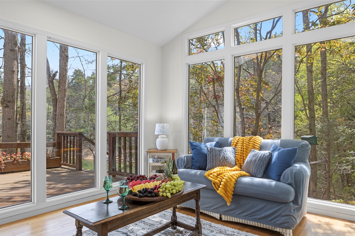 Sun Room: Discover nature through expansive windows in this charming living space!