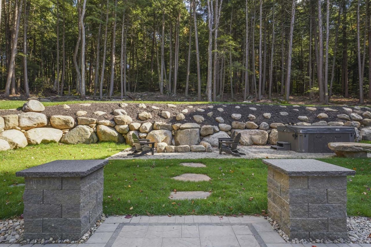 Backyard as you come directly out of the sliding patio door from the living room.  Stepping stones lead you to the custom boulder firepit
