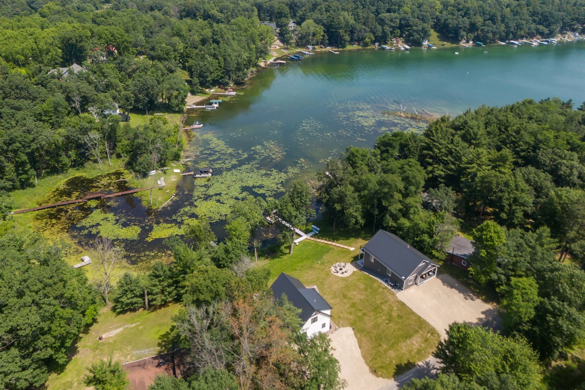 A bird’s-eye view of the property—this drone shot captures the full layout, including the house, yard, and surrounding scenery.