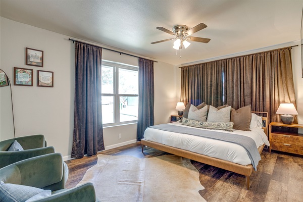 King bedroom with stylish bedding, blackout curtains, and reading lights
