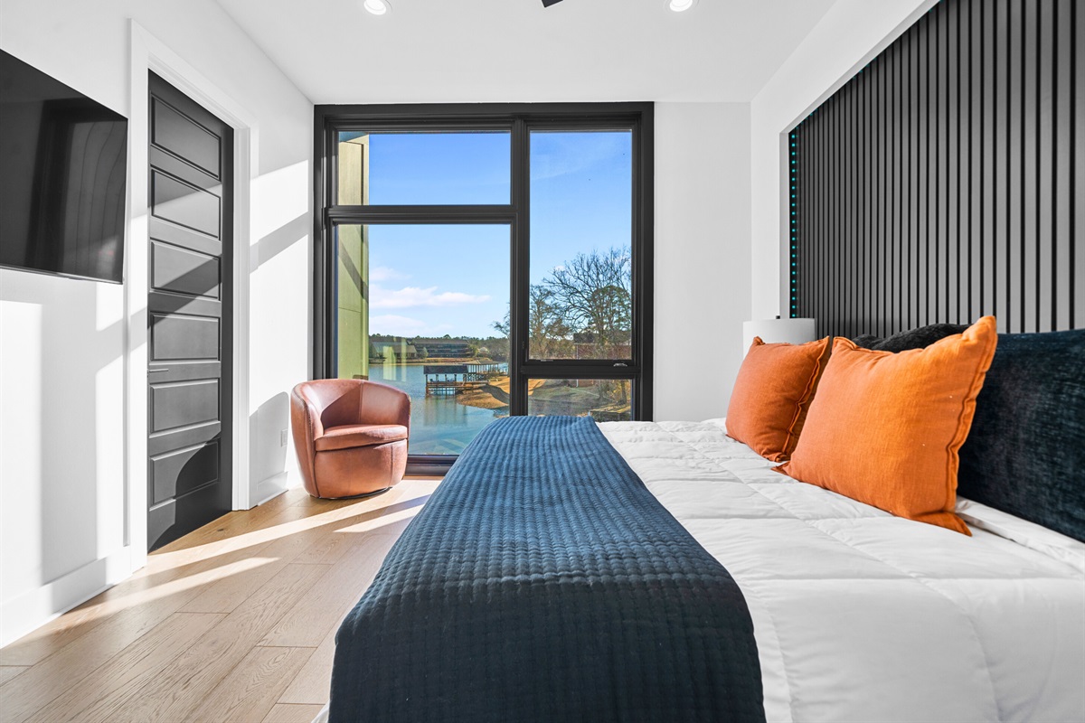 This king bedroom is both stylish and comfortable, with warm tones, elegant furnishings, and floor-to-ceiling windows that bring the outdoors in.